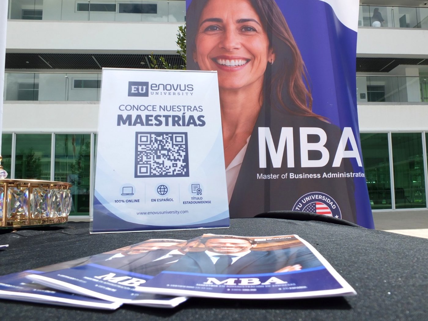 Material informativo del MBA y de las maestrías de Enovus University sobre la mesa del stand