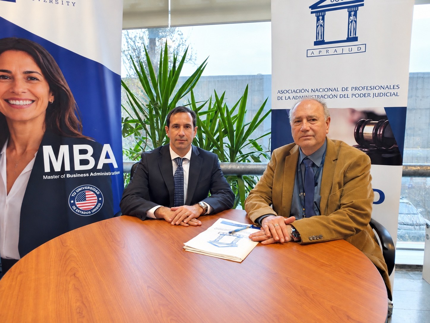 Representantes de Enovus University y APRAJUD en la firma del convenio